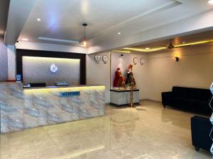 a lobby with a reception desk and a couch at The Grand Sarovar Inn And Suites in Chakan