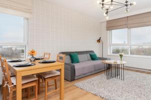 a living room with a couch and a table at 9th Floor Green and Grey Apartment in Gdańsk Brzeźno with Two Bedrooms and Parking by Renters in Gdańsk