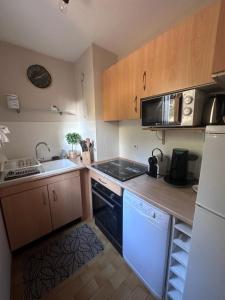 a small kitchen with a stove and a sink at Appartement front de mer in Saint-Raphaël