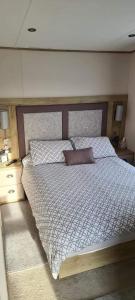 a bedroom with a large bed with a pillow on it at Beautiful holiday 3 bed Home Camber-sands in Camber
