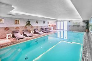 uma grande piscina com cadeiras num quarto em Leonfeldner-Hof em Bad Leonfelden