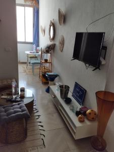 een woonkamer met een flatscreen-tv aan de muur bij Appartement 2 à Carthage byrsa in Douar ech Chott