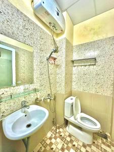 un bagno con lavandino, wc e doccia di Gold's House a Da Thanh Altre 37 foto