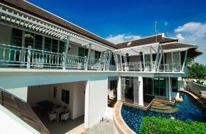 an external view of a house with a swimming pool at Paradise Pool Villa Pattaya in Tropicana Village in Jomtien Beach