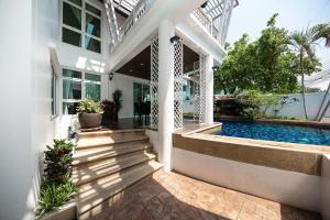 an exterior view of a house with a swimming pool at Paradise Pool Villa Pattaya in Tropicana Village in Jomtien Beach