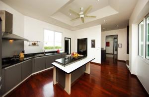 a kitchen with a table in the middle of it at Paradise Pool Villa Pattaya in Tropicana Village in Jomtien Beach