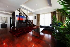 a living room with a couch and a television at Paradise Pool Villa Pattaya in Tropicana Village in Jomtien Beach