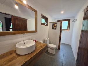 a bathroom with a sink and a toilet at Bale Kebon Rangsot in Pawenang