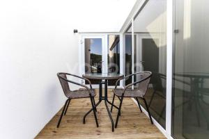 a glass table and two chairs on a balcony at Raffine Hotel in Gangneung