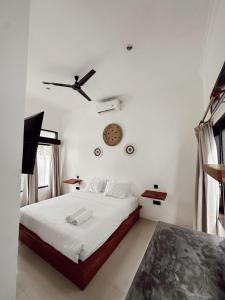 a bedroom with a bed and a clock on the wall at Susurro Residential in Kuta Lombok