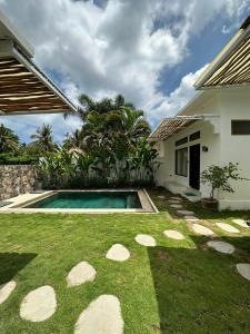 a backyard with a swimming pool and a house at Susurro Residential in Kuta Lombok