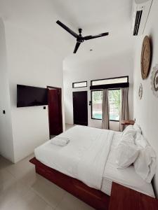 a bedroom with a large bed with a ceiling fan at Susurro Residential in Kuta Lombok