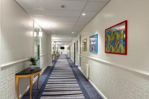 um corredor de um escritório com uma mesa e pinturas nas paredes em Copthorne Aberdeen Hotel em Aberdeen