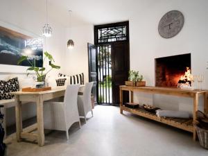 uma sala de estar com lareira e uma mesa e cadeiras em Villa da Graca em Mossel Bay