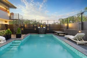 a swimming pool with two chairs and a table on a building at Hotel Blue Chip By Downtown - Near Udaipur Airport in Dabok