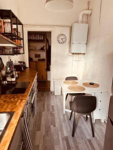 a kitchen with a table and chairs and a clock at Artsy Room for 2 in Prenzlauer Berg - Ideal Stay in Shared Flat in Berlin