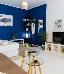 ein Wohnzimmer mit blauen Wänden und einem weißen Sofa in der Unterkunft Designed & Cozy Studio Near by Dizingoff Sqr. in Tel Aviv