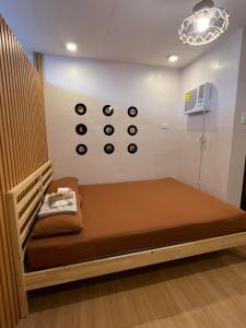 a bed in a room with clocks on the wall at Staycation in Marilao Bulacan Near Ph Arena - Swift Escape in Marilao