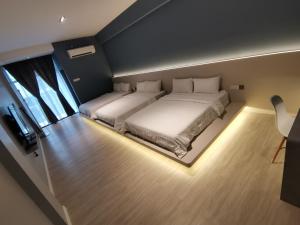 a large bedroom with two beds in it with lights at HOTEL SENTOSA KOTA BHARU Kelantan in Kota Bharu