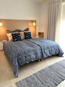 a bedroom with a large bed with a blue blanket at Villa Michael in St. Paul's Bay