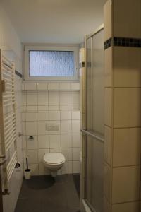 een badkamer met een toilet en een raam bij Mont Apartments in Erkrath