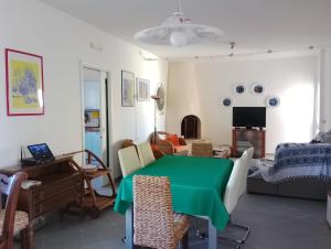 a living room with a green table and chairs at Casa Alba by My Home Apulia in Torre Lapillo