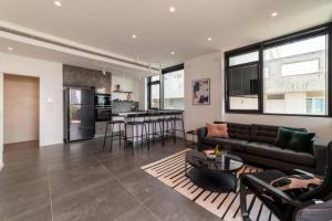 ein Wohnzimmer mit einem Sofa und einem Tisch in der Unterkunft Amazing Penthouse on Gordon Beach 8 guests in Tel Aviv
