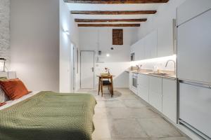 a white kitchen with a bed and a table at Stylish BORN in Barcelona
