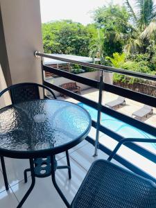 een tafel en stoelen op een balkon met een zwembad bij M-crystals in Richards Bay