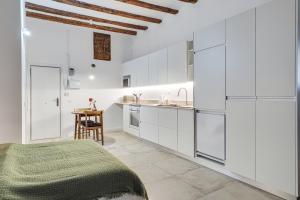 a white kitchen with white cabinets and a table at Stylish BORN in Barcelona