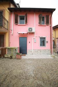 a pink house with a blue door and windows at Casa Mia in Casorate Primo