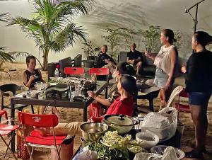 een groep mensen die rond een tafel met eten staan bij Garden Riverside in Kampot