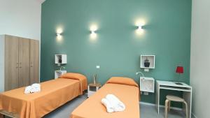2 letti in una camera d'ospedale con pareti blu di Bed & Bike Hostel a San Giovanni in Persiceto