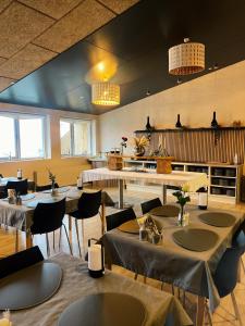 ein Restaurant mit Tischen und Stühlen in einem Zimmer in der Unterkunft KonceptHotel in Oksbøl