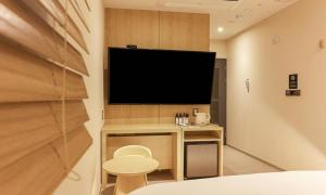 a room with a tv on a wall with a table at Wonju Brown Dot Hotel Corporate city in Wonju +51 photos