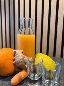 a bottle of orange juice and two glasses of oranges at KonceptHotel in Oksbøl
