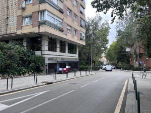 una strada vuota di fronte a un palazzo alto di Rooms Luxury Madrid a Madrid
