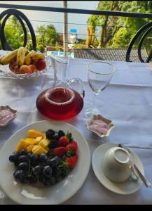 a table with a plate of fruit and a drink at Le Bamboo Guest House And Boat Cruise in Hartbeespoort