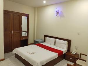 a bedroom with a bed with a red and white blanket at Hotel Bông Sen in Ho Chi Minh City