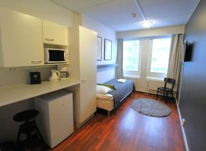 ラハティにあるForenom Aparthotel Lahtiのベッドとリビングルームが備わる小さな客室です。