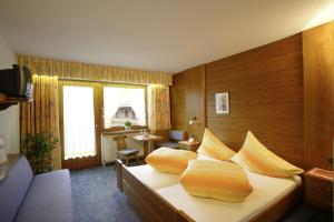 a hotel room with a bed with yellow pillows at Haus Erwin Appartement in Sölden