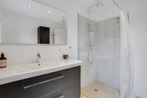 a white bathroom with a sink and a shower at Fuhlendorff Ferieboliger - Ballum in Bredebro