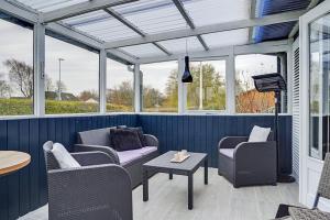 a screened in porch with chairs and a table at Fuhlendorff Ferieboliger - Ballum in Bredebro