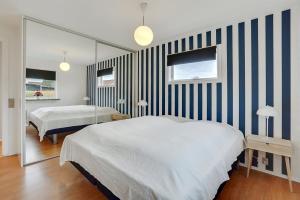 a bedroom with two beds and a mirror at Fuhlendorff Ferieboliger - Ballum in Bredebro
