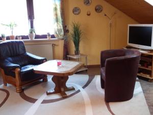 sala de estar con 2 sillas, mesa y TV en Ferienwohnung Georg en Boppard