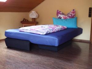 Cama en habitación con sábanas y almohadas azules en Ferienwohnung Georg, en Boppard