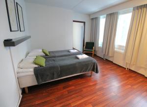 a bedroom with a bed and a chair in it at Forenom Aparthotel Lahti in Lahti