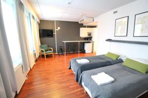 a hotel room with two beds and a table at Forenom Aparthotel Lahti in Lahti
