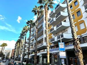 a tall building with palm trees in front of a street at center SUITE sorrento baby 2 in Sorrento