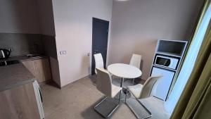 a small kitchen with a white table and chairs at Horizon Hotel in Odesa